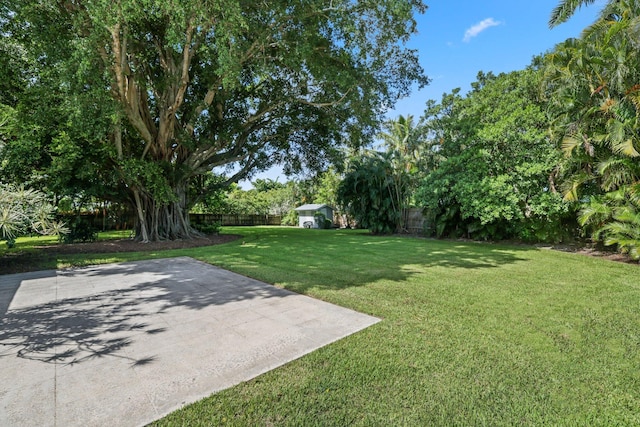 920 Hibiscus Ln, Delray Beach, FL 33444 - view of yard featuring a fenced backyard, a storage unit, a patio, and an outdoor structure