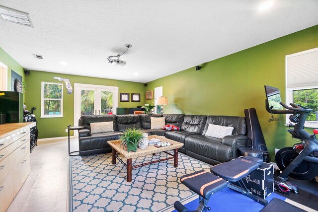 living room with a textured ceiling and french doors