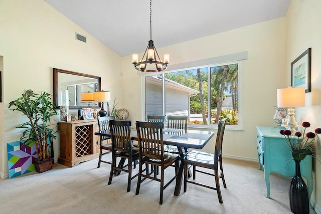 carpeted dining room with a notable chandelier and vaulted ceiling