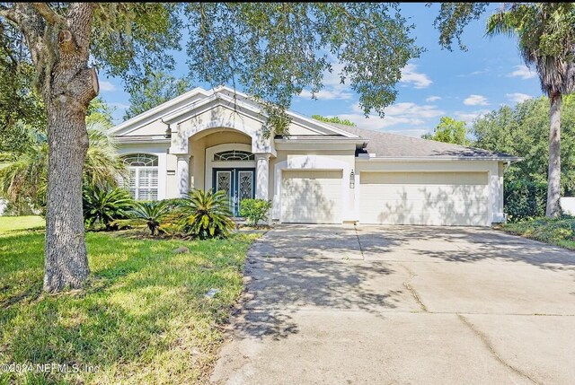 ranch-style home featuring a garage and a front yard