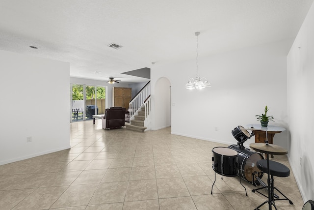 interior space featuring arched walkways, light tile patterned flooring, visible vents, baseboards, and stairs