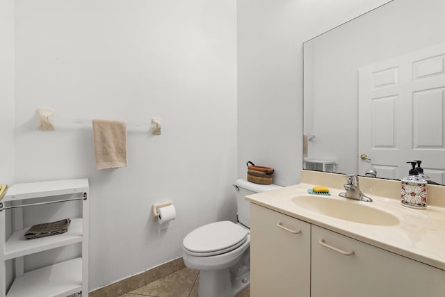 half bathroom featuring toilet, tile patterned flooring, baseboards, and vanity