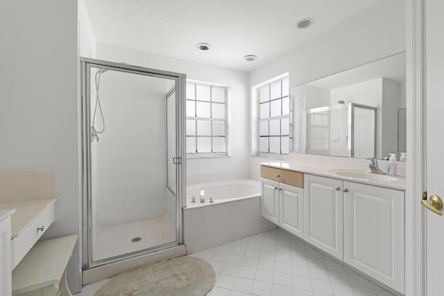 full bath featuring a stall shower, tile patterned floors, a garden tub, and vanity