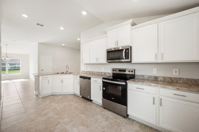 kitchen featuring stainless steel appliances, white cabinets, kitchen peninsula, lofted ceiling, and light tile patterned floors