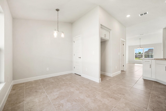 unfurnished room with light tile patterned floors and an inviting chandelier