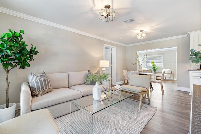 living room with crown molding, hardwood / wood-style floors, and a notable chandelier