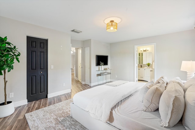 bedroom featuring connected bathroom and hardwood / wood-style floors