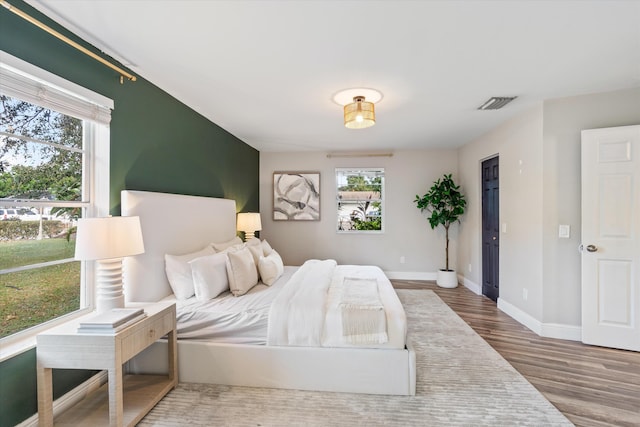 bedroom featuring hardwood / wood-style floors and multiple windows