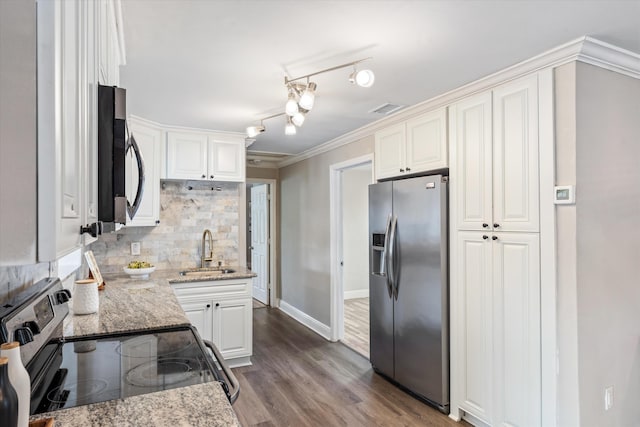 kitchen featuring stainless steel appliances, white cabinetry, light stone countertops, and sink