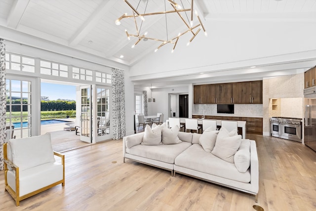 living room with light hardwood / wood-style floors, beam ceiling, high vaulted ceiling, an inviting chandelier, and wooden ceiling