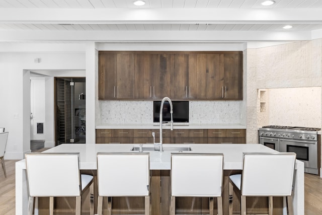 kitchen with high end stove, beam ceiling, and decorative backsplash