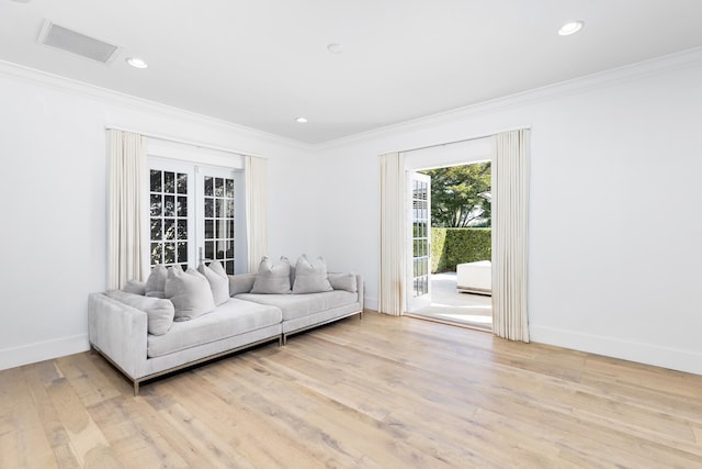 living room featuring french doors, light hardwood / wood-style flooring, and ornamental molding