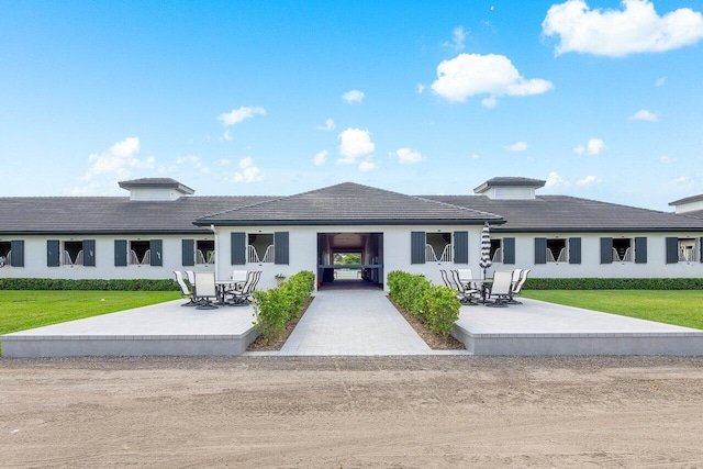 view of front of home with a patio and a front yard