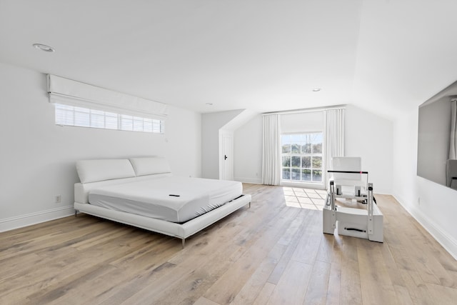 bedroom featuring lofted ceiling and light hardwood / wood-style flooring