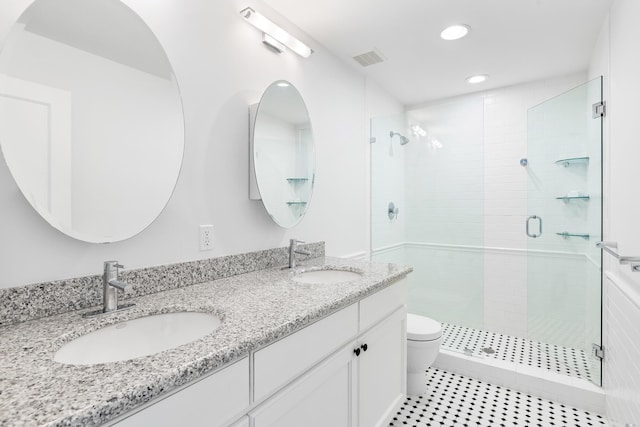 bathroom with a shower with door, vanity, and toilet