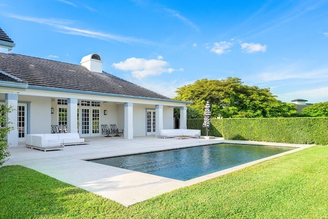 view of pool with a patio area, french doors, and a yard