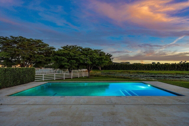 pool at dusk with a lawn