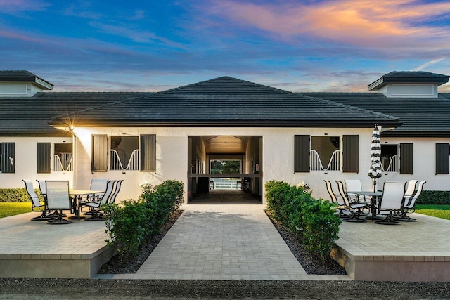 exterior entry at dusk with a patio