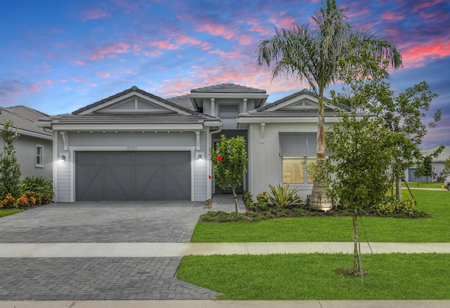 view of front facade with a garage and a lawn