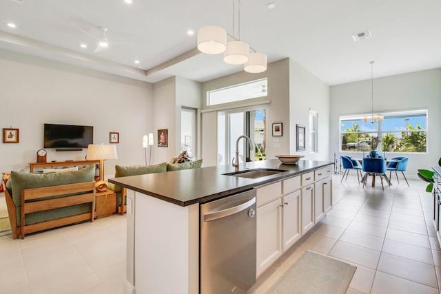 kitchen with a kitchen island with sink, hanging light fixtures, white cabinets, and stainless steel dishwasher