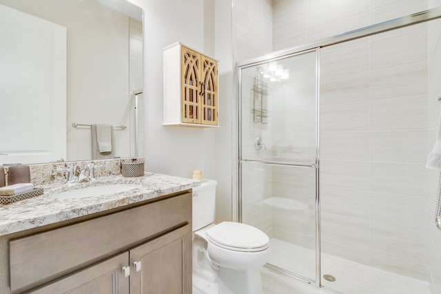 bathroom with an enclosed shower, vanity, and toilet