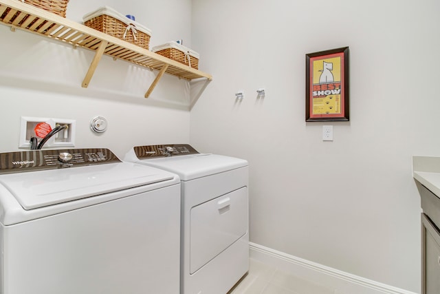 clothes washing area with independent washer and dryer and light tile patterned floors