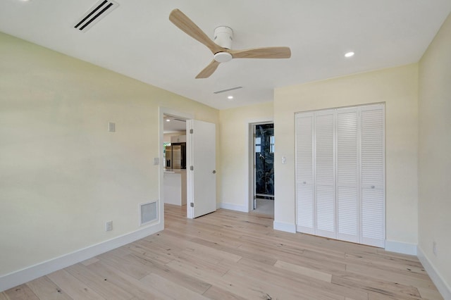 unfurnished bedroom featuring light wood-type flooring, ceiling fan, and a closet