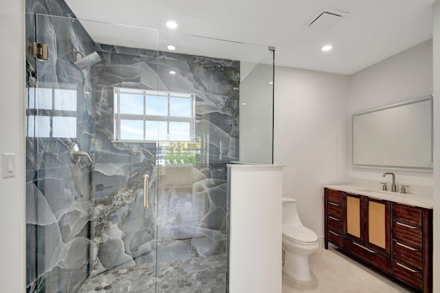 bathroom with vanity, toilet, and a shower with door