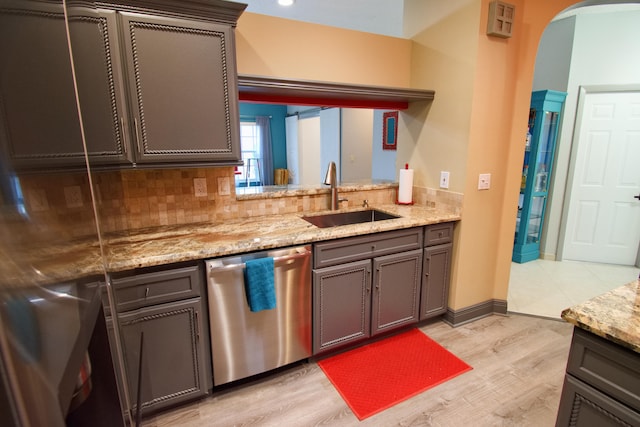 kitchen featuring light hardwood / wood-style floors, stainless steel dishwasher, tasteful backsplash, sink, and light stone countertops