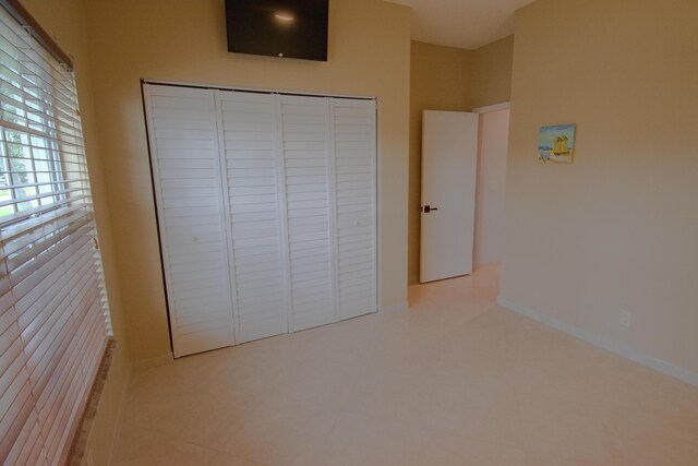 unfurnished bedroom featuring a closet and light tile patterned floors