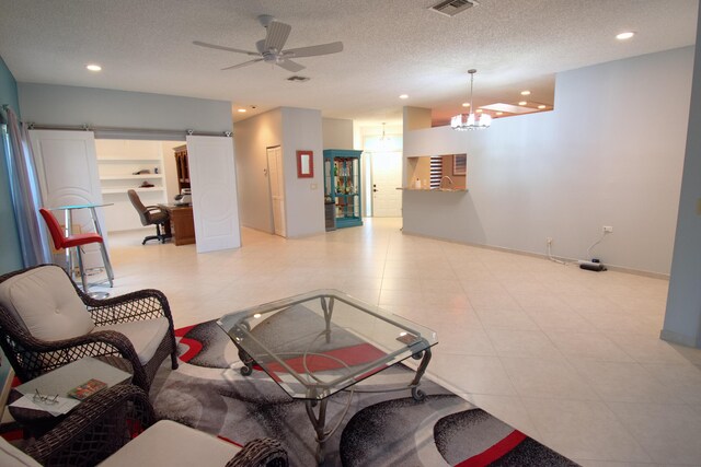 tiled living room featuring ceiling fan with notable chandelier, a textured ceiling, and built in features