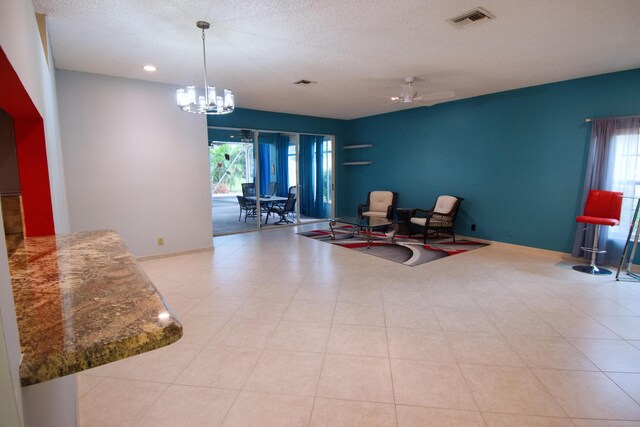 interior space featuring a wealth of natural light, ceiling fan with notable chandelier, and light tile patterned floors