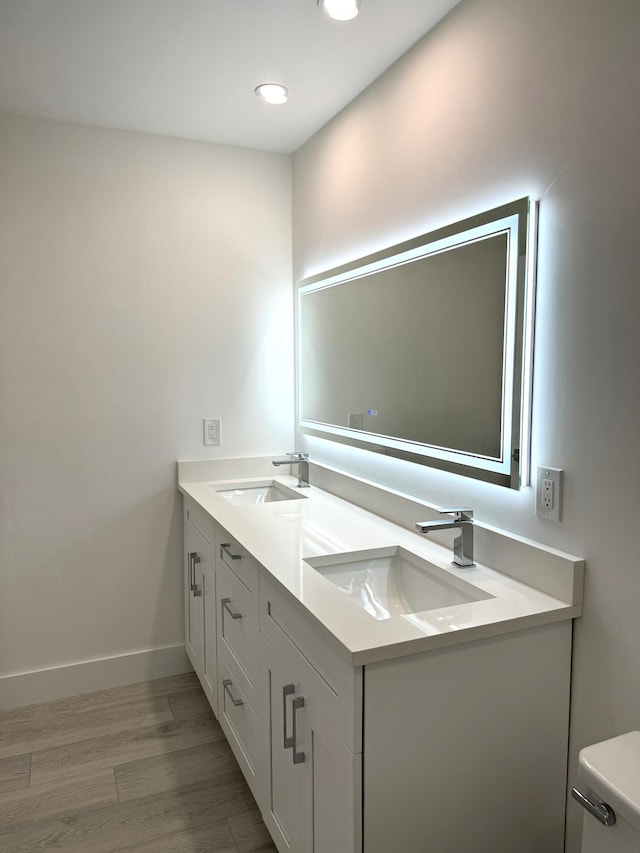 bathroom with hardwood / wood-style floors, toilet, and vanity