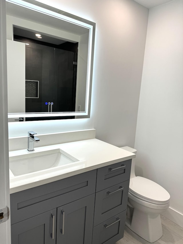 bathroom featuring toilet, hardwood / wood-style floors, and vanity