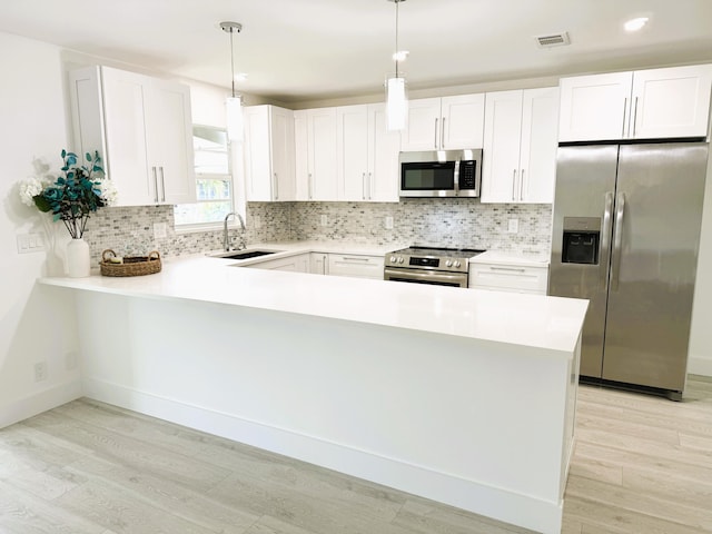 kitchen with white cabinetry, sink, stainless steel appliances, and decorative backsplash