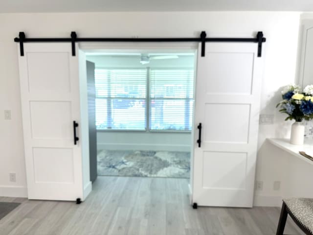 1090 N Dr Unit C, Delray Beach, FL 33445 - interior space with a barn door, light wood-type flooring, and baseboards