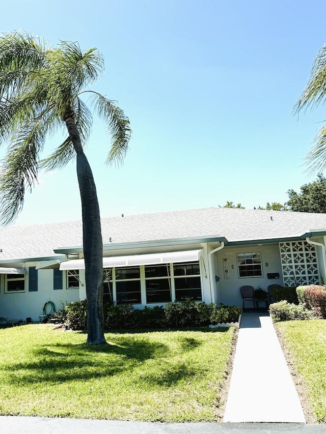 ranch-style home with stucco siding and a front yard