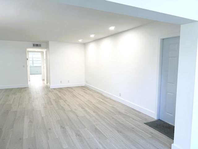 below grade area with light wood-type flooring, baseboards, visible vents, and recessed lighting