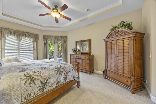 carpeted bedroom with ceiling fan, access to exterior, and a tray ceiling