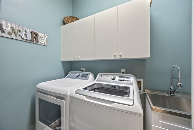 laundry area with washer and clothes dryer, sink, and cabinets