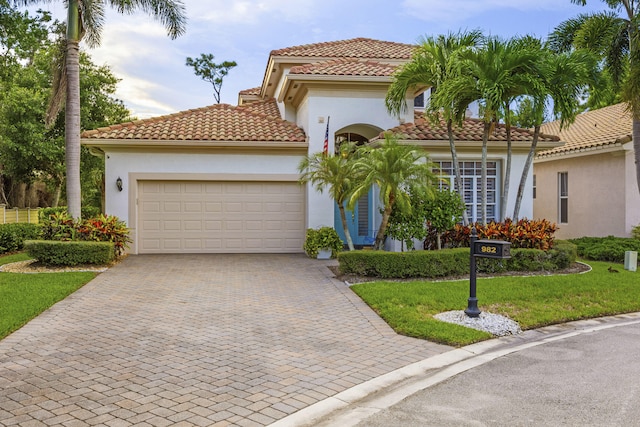 mediterranean / spanish home featuring a front lawn and a garage