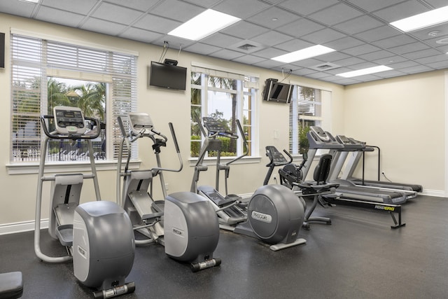 exercise room featuring a drop ceiling and a wealth of natural light