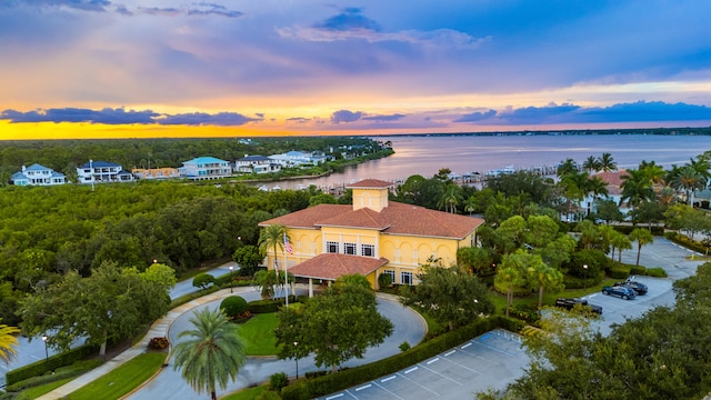 aerial view at dusk featuring a water view