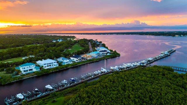 aerial view at dusk featuring a water view