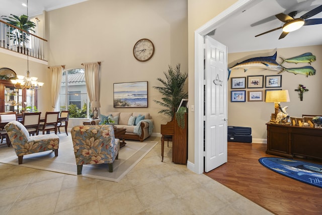 living room featuring light tile patterned floors and ceiling fan with notable chandelier