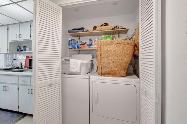 clothes washing area featuring sink and washing machine and clothes dryer