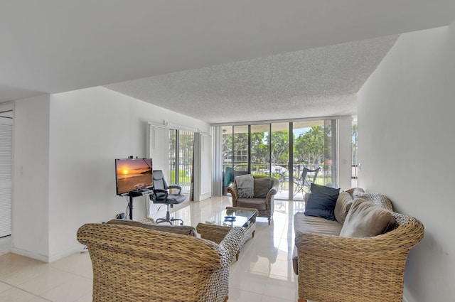 tiled living room featuring a textured ceiling and floor to ceiling windows