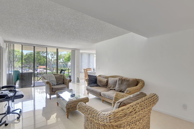 living room with plenty of natural light, a textured ceiling, and a wall of windows