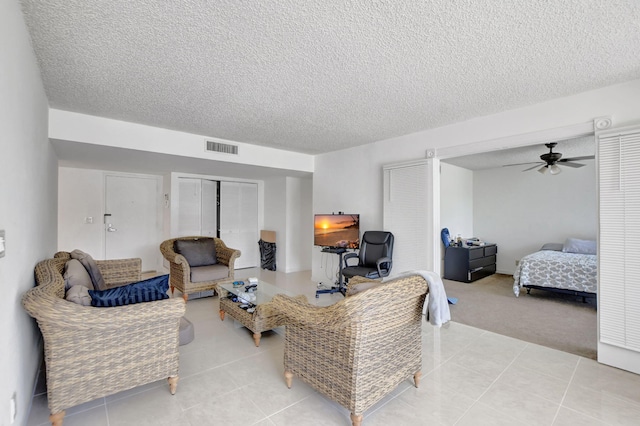 carpeted living room featuring a textured ceiling and ceiling fan