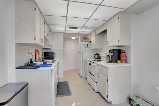 kitchen featuring light tile patterned flooring, backsplash, sink, white appliances, and white cabinets